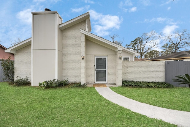 619 Shenandoah Dr, Shenandoah, TX 77381 - mid-century modern home featuring brick siding, a front lawn, fence, and a chimney