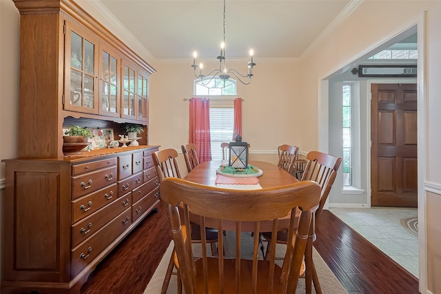 dining room featuring an inviting chandelier, ornamental molding, and wood finished floors