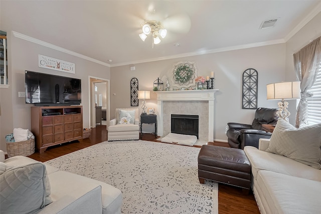 living area with crown molding, dark wood-style flooring, a ceiling fan, and visible vents