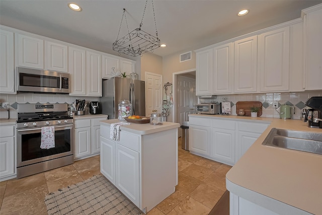 kitchen featuring light countertops, white cabinetry, backsplash, and appliances with stainless steel finishes