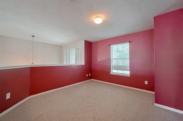 carpeted empty room featuring baseboards