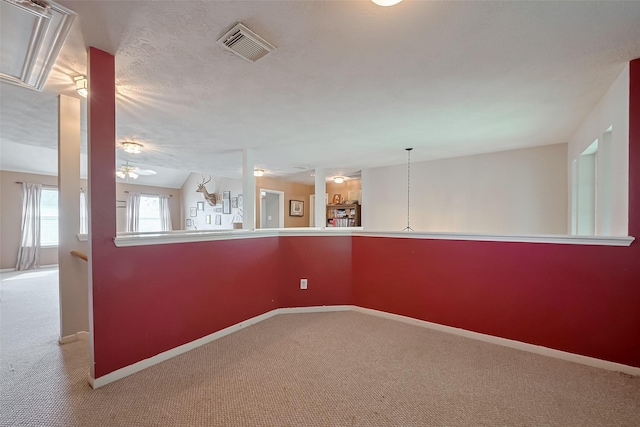 empty room featuring visible vents, ceiling fan, carpet floors, and baseboards