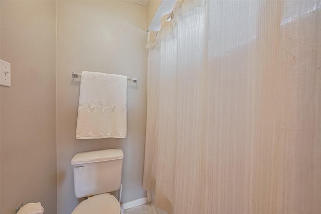 bathroom with toilet and baseboards