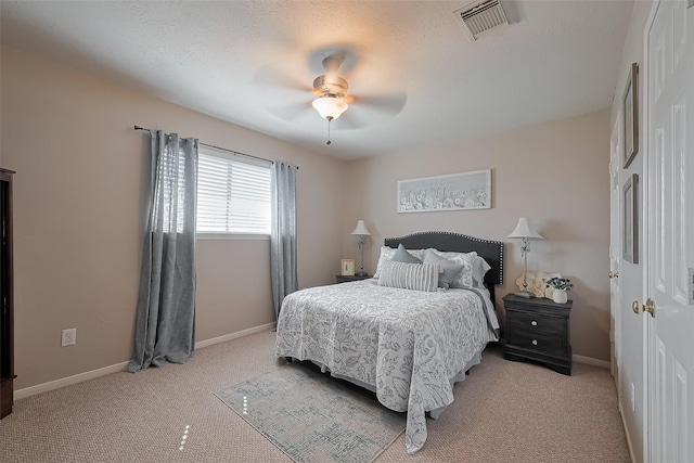 bedroom featuring light carpet, visible vents, baseboards, and a ceiling fan