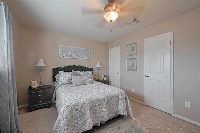 carpeted bedroom with visible vents, baseboards, and a ceiling fan