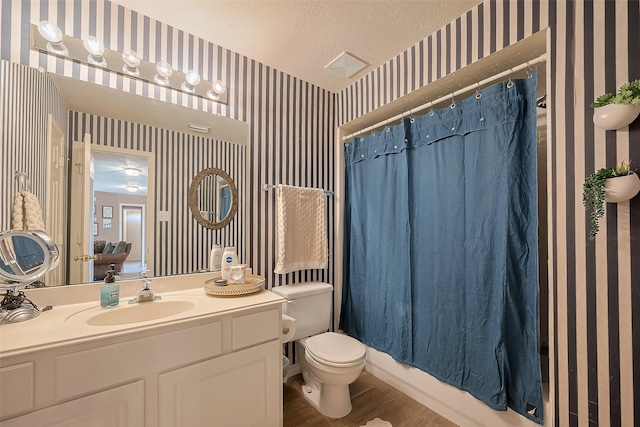 full bathroom with vanity, a shower with curtain, visible vents, toilet, and wallpapered walls