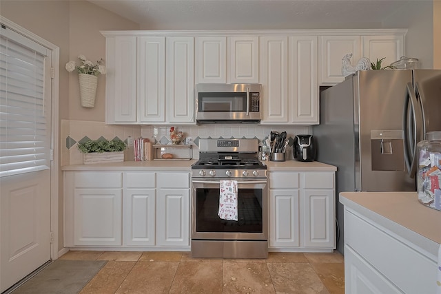 kitchen featuring stainless steel appliances, tasteful backsplash, light countertops, and white cabinetry