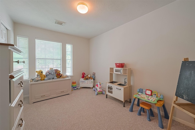 game room with light carpet, a wealth of natural light, visible vents, and baseboards
