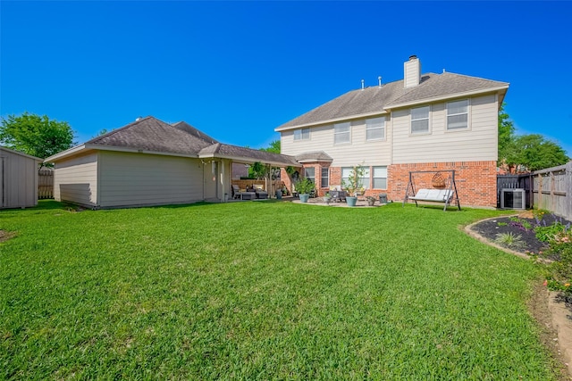 rear view of house with a patio, brick siding, a yard, and cooling unit