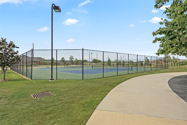 view of sport court featuring a yard and fence