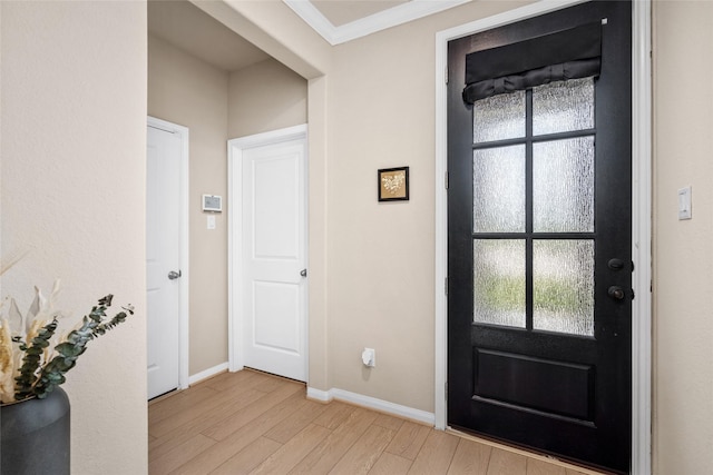 entrance foyer with crown molding, light wood finished floors, and baseboards