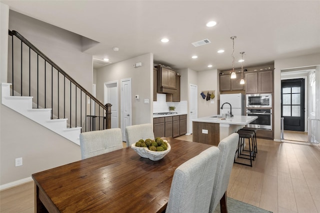 dining space with visible vents, baseboards, stairway, recessed lighting, and light wood-style flooring