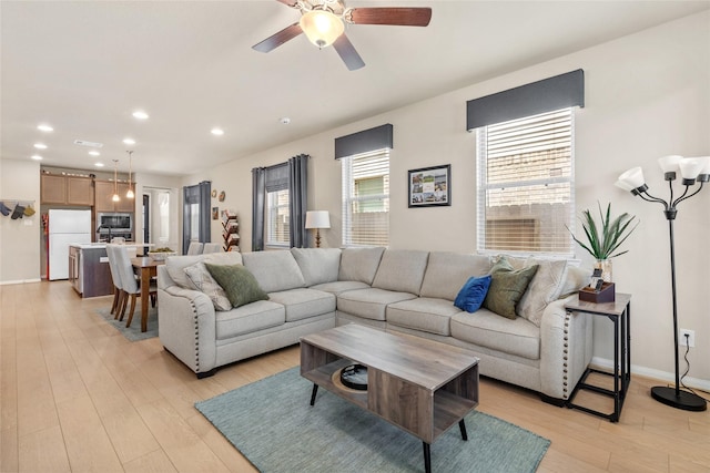 living room with ceiling fan, light wood finished floors, recessed lighting, and baseboards