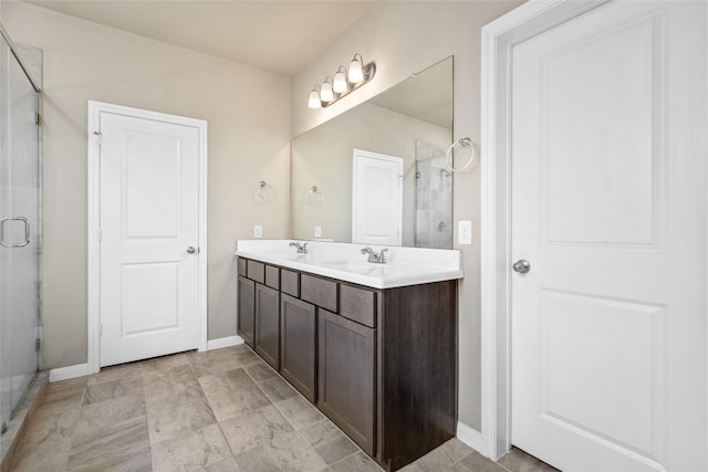 bathroom featuring double vanity, baseboards, a sink, and a stall shower