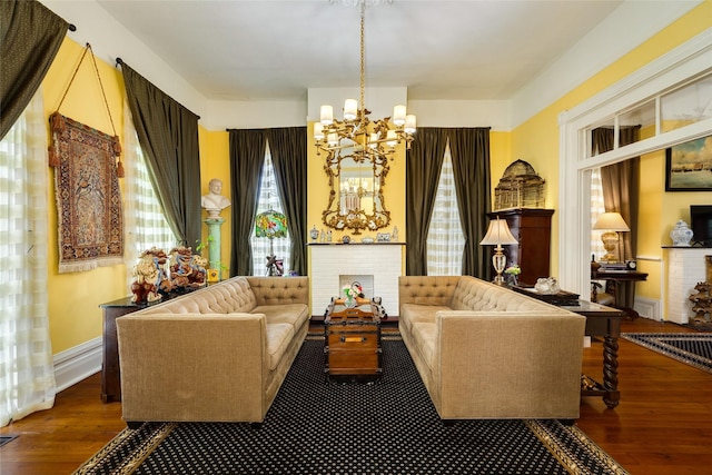 sitting room featuring a notable chandelier, baseboards, visible vents, and wood finished floors