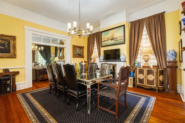 dining space featuring hardwood / wood-style floors, a notable chandelier, and baseboards