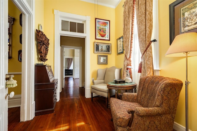 sitting room with baseboards, ornamental molding, and hardwood / wood-style flooring