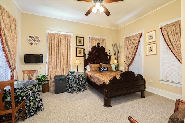 bedroom with crown molding, ceiling fan, baseboards, and carpet