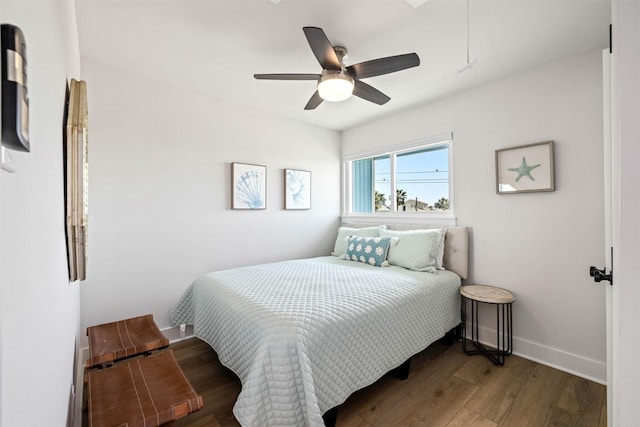 bedroom featuring baseboards, a ceiling fan, attic access, and wood finished floors