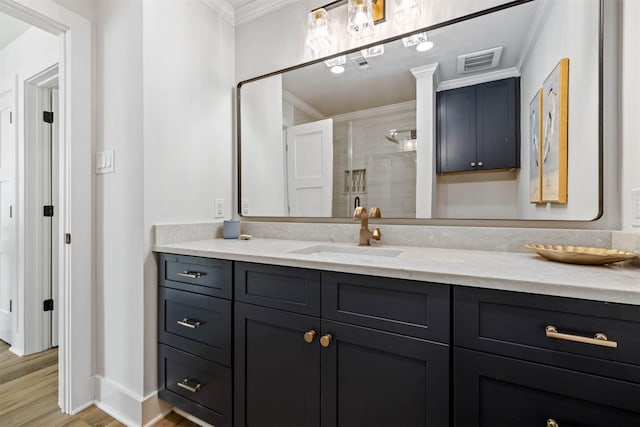 bathroom featuring vanity, ornamental molding, visible vents, a stall shower, and baseboards