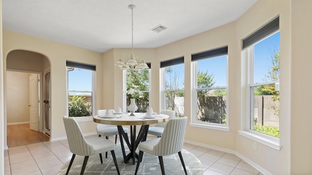 dining room featuring light tile patterned flooring, plenty of natural light, and visible vents