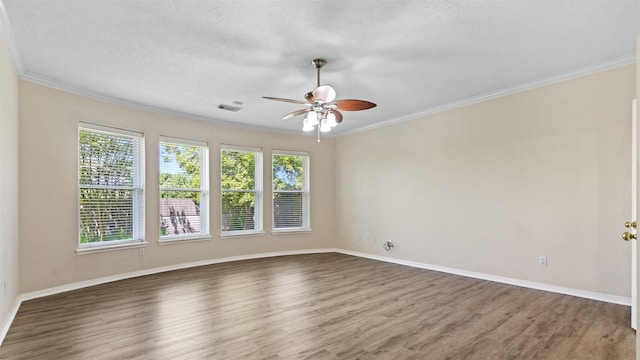 unfurnished room featuring crown molding, a ceiling fan, wood finished floors, and visible vents