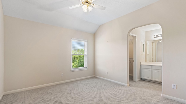 unfurnished bedroom with light carpet, baseboards, and arched walkways