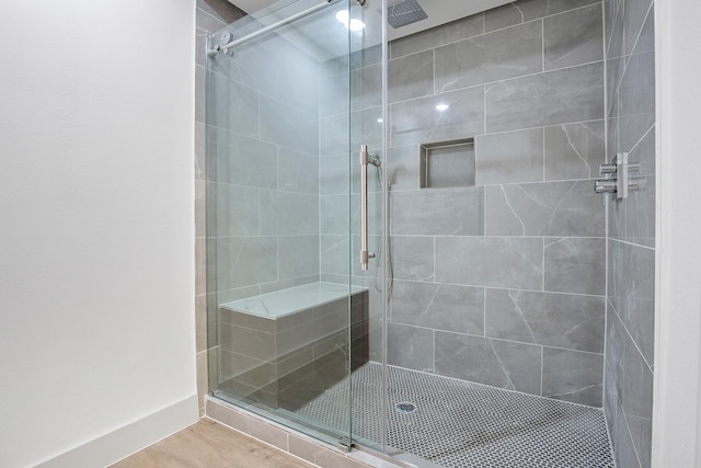full bath featuring a shower stall and wood finished floors