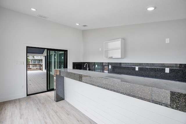 kitchen with dark stone countertops, visible vents, light wood finished floors, and recessed lighting