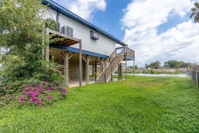 rear view of house featuring a yard, central AC, a patio, and stairs