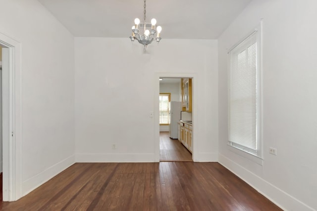 428 E Magnolia St, Angleton, TX 77515 - empty room featuring dark wood-type flooring, baseboards, and an inviting chandelier