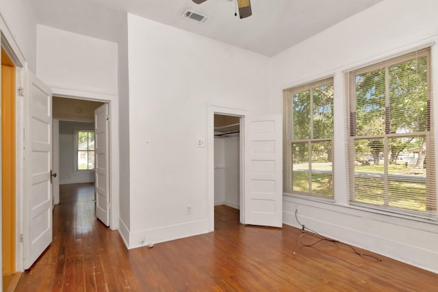 428 E Magnolia St, Angleton, TX 77515 - unfurnished bedroom with baseboards, a spacious closet, a ceiling fan, visible vents, and wood finished floors