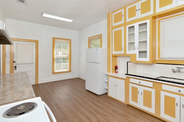 428 E Magnolia St, Angleton, TX 77515 - kitchen with light wood-style flooring, freestanding refrigerator, light countertops, and decorative backsplash