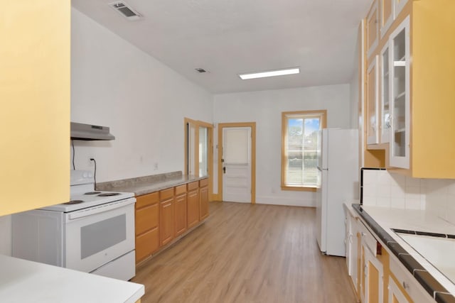 428 E Magnolia St, Angleton, TX 77515 - kitchen with white appliances, light countertops, under cabinet range hood, visible vents, and light wood finished floors