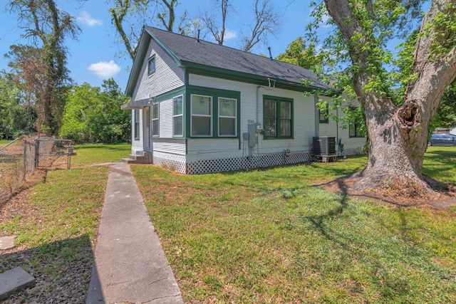 428 E Magnolia St, Angleton, TX 77515 - bungalow-style home with central AC unit, entry steps, fence, a front lawn, and roof with shingles