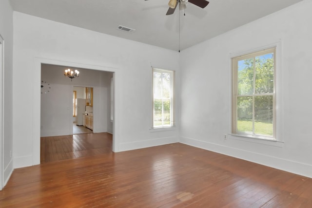 428 E Magnolia St, Angleton, TX 77515 - unfurnished room featuring visible vents, wood-type flooring, plenty of natural light, and ceiling fan with notable chandelier