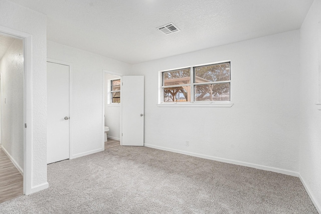 unfurnished bedroom featuring visible vents, baseboards, and carpet