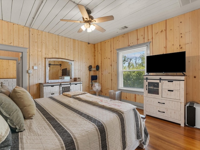 602 W 1st St, Freeport, TX 77541 - bedroom with wooden walls, wood finished floors, wooden ceiling, and ceiling fan