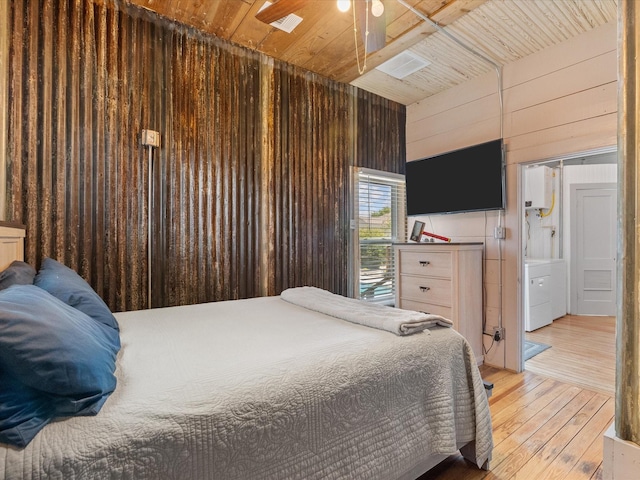 602 W 1st St, Freeport, TX 77541 - bedroom featuring wood ceiling, wooden walls, light wood-type flooring, independent washer and dryer, and water heater