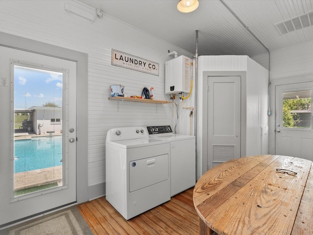 602 W 1st St, Freeport, TX 77541 - laundry room featuring water heater, washer and clothes dryer, and light wood finished floors