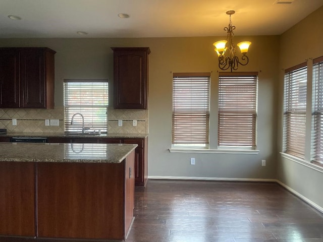 kitchen featuring dark wood-type flooring, a sink, an inviting chandelier, and tasteful backsplash
