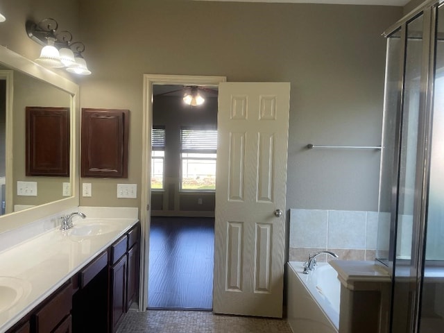 bathroom with a sink, double vanity, and a bath