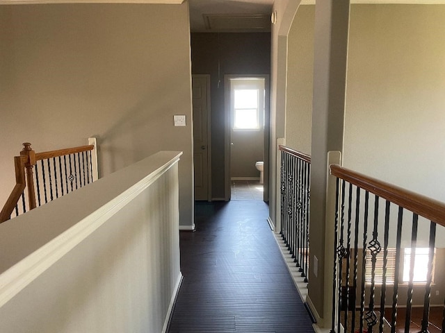 corridor featuring baseboards and an upstairs landing