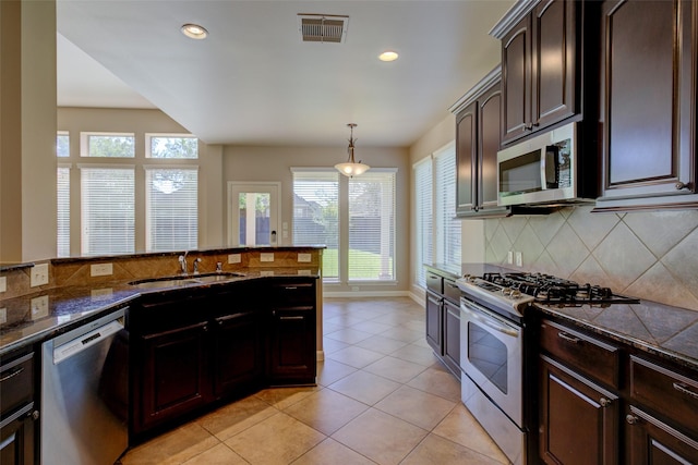 6103 Silver Thistle Ln, Fulshear, TX 77441 - kitchen featuring stainless steel appliances, backsplash, recessed lighting, light tile patterned flooring, and dark brown cabinetry