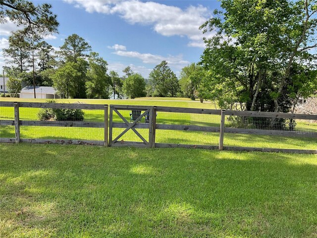 view of gate featuring a lawn and fence