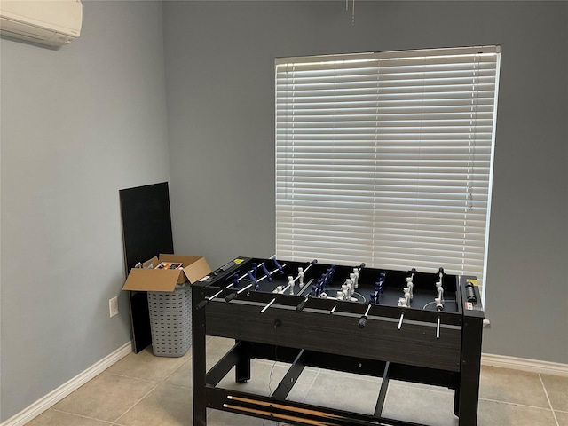 game room with a wall mounted air conditioner, baseboards, and tile patterned flooring