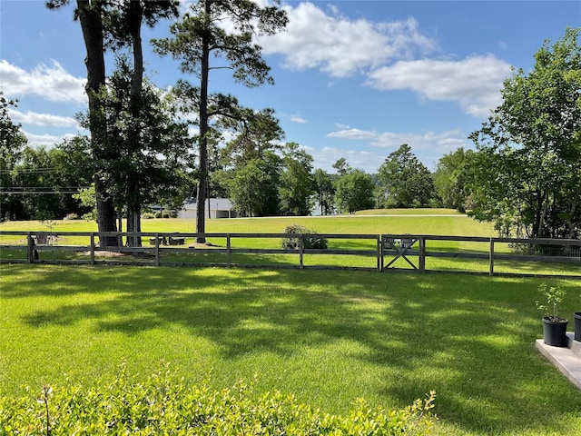 view of property's community featuring fence and a yard