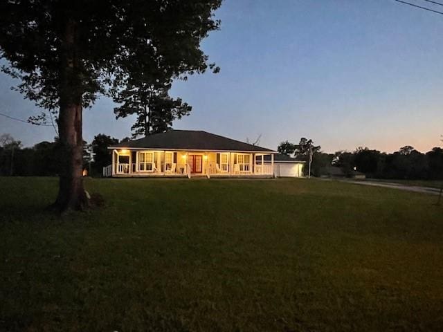 rear view of property with a lawn and covered porch