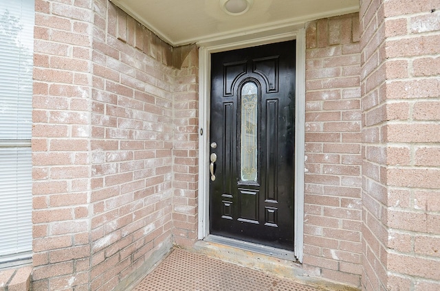 doorway to property featuring brick siding
