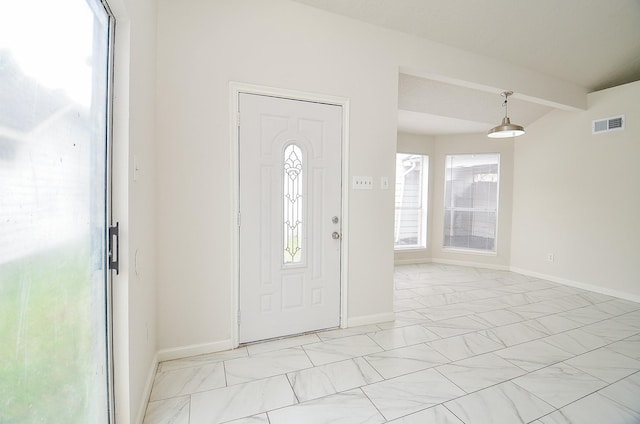 entrance foyer featuring baseboards, plenty of natural light, visible vents, and beam ceiling